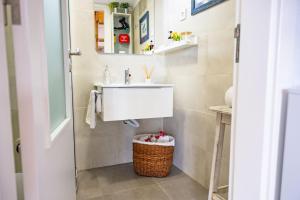 a bathroom with a sink and a basket at Mourisco Guest House in Alijó