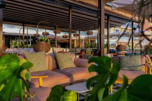 a restaurant with couches and tables and plants at Catalonia Majórica in Palma de Mallorca