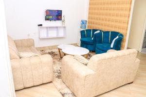 a living room with two chairs and a couch at Karani Suites in Nyahururu