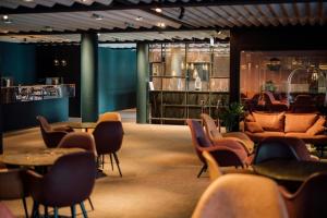 a lobby with tables and chairs and a bar at Hotel Føroyar in Tórshavn