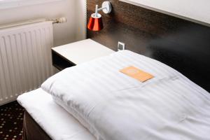 a bed with a book on top of it at Hotel Tórshavn in Tórshavn