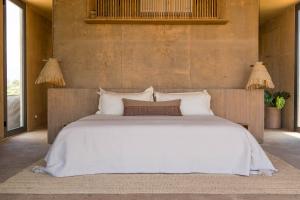 a bedroom with a large bed with white sheets and pillows at Paradero Todos Santos - Exclusive experiences included in Todos Santos