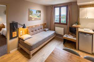 a small living room with a couch and a table at Résidence L'Atelier in Ennezat