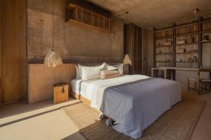 a bedroom with a white bed and a table at Paradero Todos Santos - Exclusive experiences included in Todos Santos