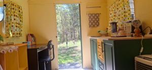 a kitchen with a sliding glass door to a yard at Truck Caravan Rustic Sunflower in Mount Crosby