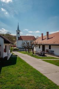 a path leading to a white building with a church at Villány Outback in Kisjakabfalva +14 photos