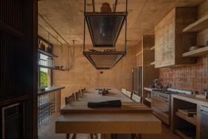 a kitchen with a long wooden table in a room at Paradero Todos Santos - Exclusive experiences included in Todos Santos