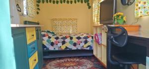 a small room with a bed and a desk at Truck Caravan Rustic Sunflower in Mount Crosby