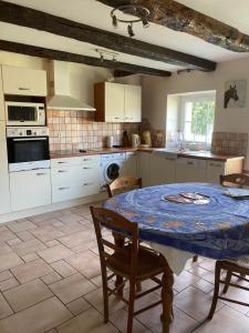 a kitchen with a table with a blue table cloth on it at Sci Licorne d Or in Saint-Méloir-des-Ondes
