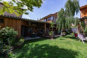 a backyard of a house with a patio and grass at Logement Bourbon - coeur Ardèche in Lamastre
