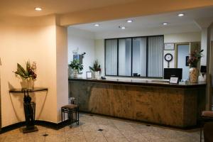 a lobby with a reception desk in a hotel at Hotel Vila Rica Flat in Resende