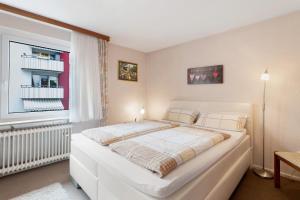 a large white bed in a room with a window at Ferienwohnung Mand in Weinheim