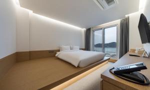 a bedroom with a bed and a desk with a computer at Bluefrog Hotel in Incheon +53 photos
