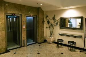 a lobby with two chairs and a mirror on the wall at Hotel Vila Rica Flat in Resende +14 photos