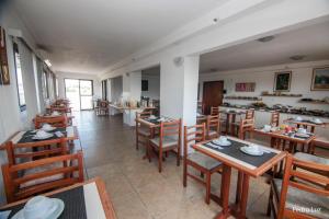 a dining room with wooden tables and chairs at Hotel Vila Rica Flat in Resende