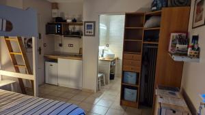 a bedroom with a bed and a kitchen with a desk at Chez Florence et Bruno in Saint-Cyr-sur-Mer