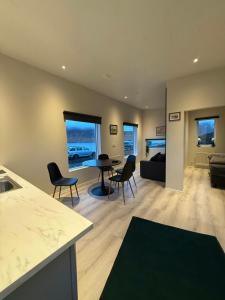 a kitchen and living room with a table and chairs at Kirkjufell View Cottages in Grundarfjordur