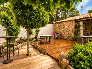 a wooden deck with tables and a tree at B&B Arghjola in Porto-Vecchio