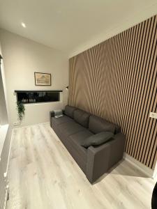 a living room with a couch and a wooden wall at Kirkjufell View Cottages in Grundarfjordur +13 photos