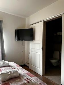 a bedroom with a bed and a flat screen tv on the wall at Hotel Skógá by EJ Hotels in Skogar