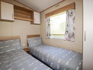 two beds in a small room with a window at The Oakley in Par