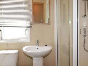 a bathroom with a sink and a toilet and a window at The Oakley in Par +15 photos