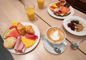 a table with plates of breakfast foods and a cup of coffee at Reykjavik Lights Hotel by Keahotels in Reykjavík