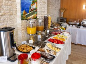 ein Buffet mit Speisen und Getränken auf einem Tisch in der Unterkunft Hotel Luxury in Ksamil