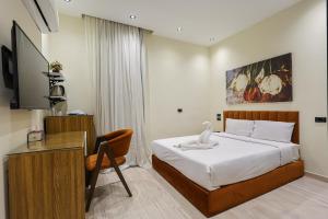 a bedroom with a bed and a desk and a television at Elite Boutique Hotel in Cairo