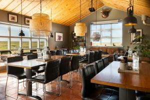 a restaurant with wooden ceilings and tables and chairs at Hestheimar in Hella +127 photos