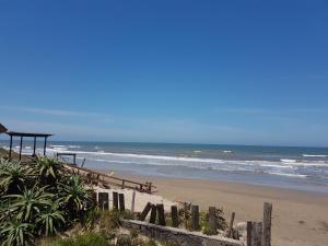 a beach with a wooden fence and the ocean at Los Lachos in Aguas Dulces