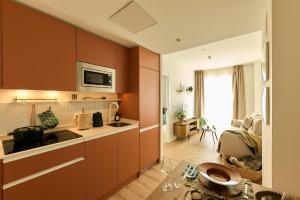 a kitchen with brown cabinets and a living room at Be Casa Sant Cugat in Sant Cugat del Vallès