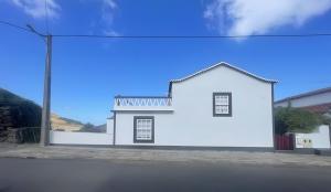 a white house on the side of a street at Casa Baía da Lagoa in Lagoa