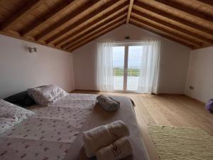 a bedroom with a large bed and a large window at Casa Baía da Lagoa in Lagoa