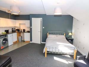 a bedroom with a bed and a kitchen at Apartment 2 in Aberdeen