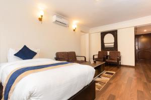 a hotel room with a bed and a table and chairs at Kathmandu Business Hotel in Kathmandu