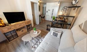 a living room with a couch and a flat screen tv at L'Escapade Pannessac troisième étage in Le Puy-en-Velay