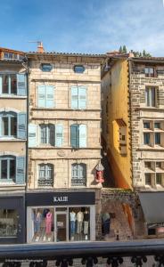 a large building with a store in front of it at L'Escapade Pannessac troisième étage in Le Puy-en-Velay