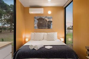 a bedroom with a bed with two towels on it at Lara Grove Cottage 2 by Tiny Away in Purdeet
