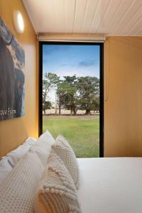 a bedroom with a bed with a view of a window at Lara Grove Cottage 2 by Tiny Away in Purdeet