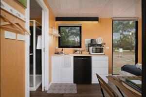 a small kitchen with a sink and a microwave at Lara Grove Cottage 2 by Tiny Away in Purdeet
