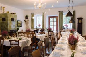 a dining room with white tables and chairs with flowers on them at Dom Sokolik in Trzcińsko