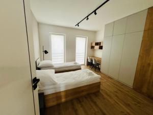 a bedroom with two beds and a desk in it at Słoneczny Taras in Kęty