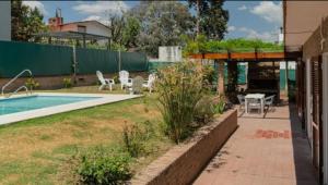 a backyard with a pool and a table and chairs at El descanso - Costa Azul in Villa Carlos Paz