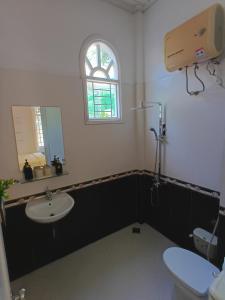 a bathroom with a sink and a toilet and a window at Green hill side Villa in Cồn Giả Viên +35 photos