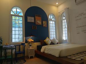 a bedroom with a bed and a blue wall at Green hill side Villa in Cồn Giả Viên