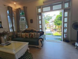 a living room with a couch and an open door at Green hill side Villa in Cồn Giả Viên