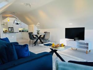 a living room with a blue couch and a tv at Island Point Horizon View in Lymington