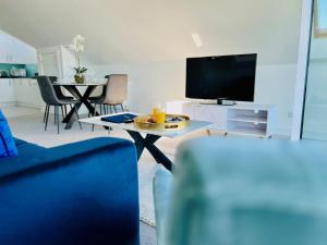 a living room with a table and a tv at Island Point Horizon View in Lymington +15 photos