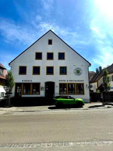 a green car parked in front of a building at Neros Hotel in Siegenburg +1 photo